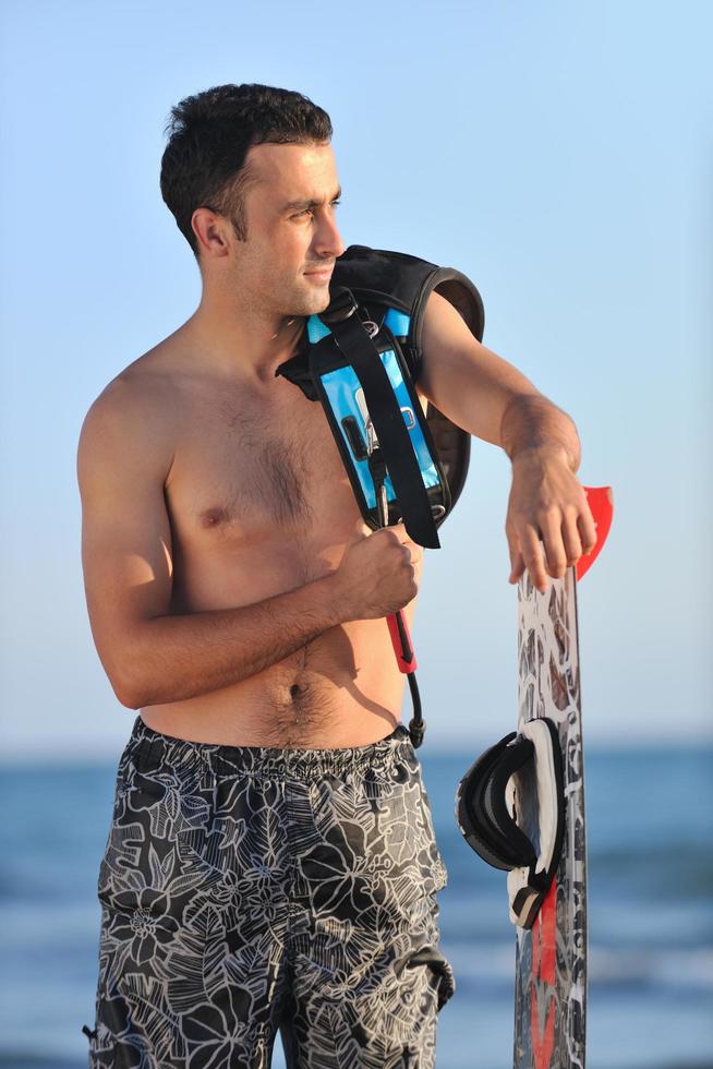 Portrait of a young  kitsurf  man at beach on sunset photo