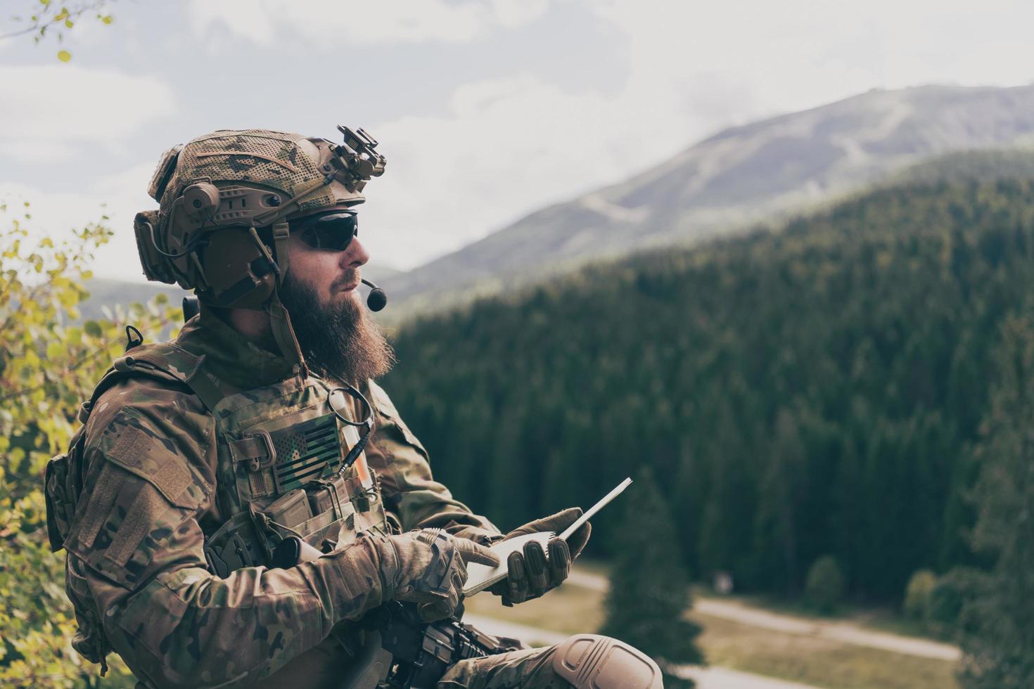 War concept. Bearded soldier in uniform of special forces in dangerous military action in dangerous enemy area studies attack tactics. Selective focus photo