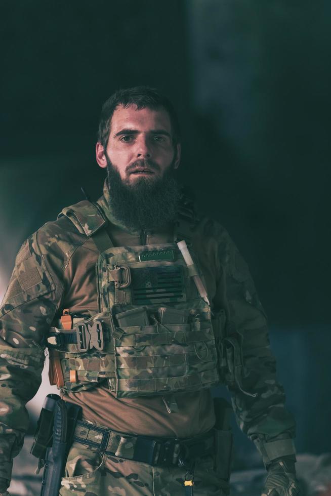 un soldado barbudo con uniforme de fuerzas especiales en una peligrosa acción militar en una peligrosa zona enemiga. enfoque selectivo foto