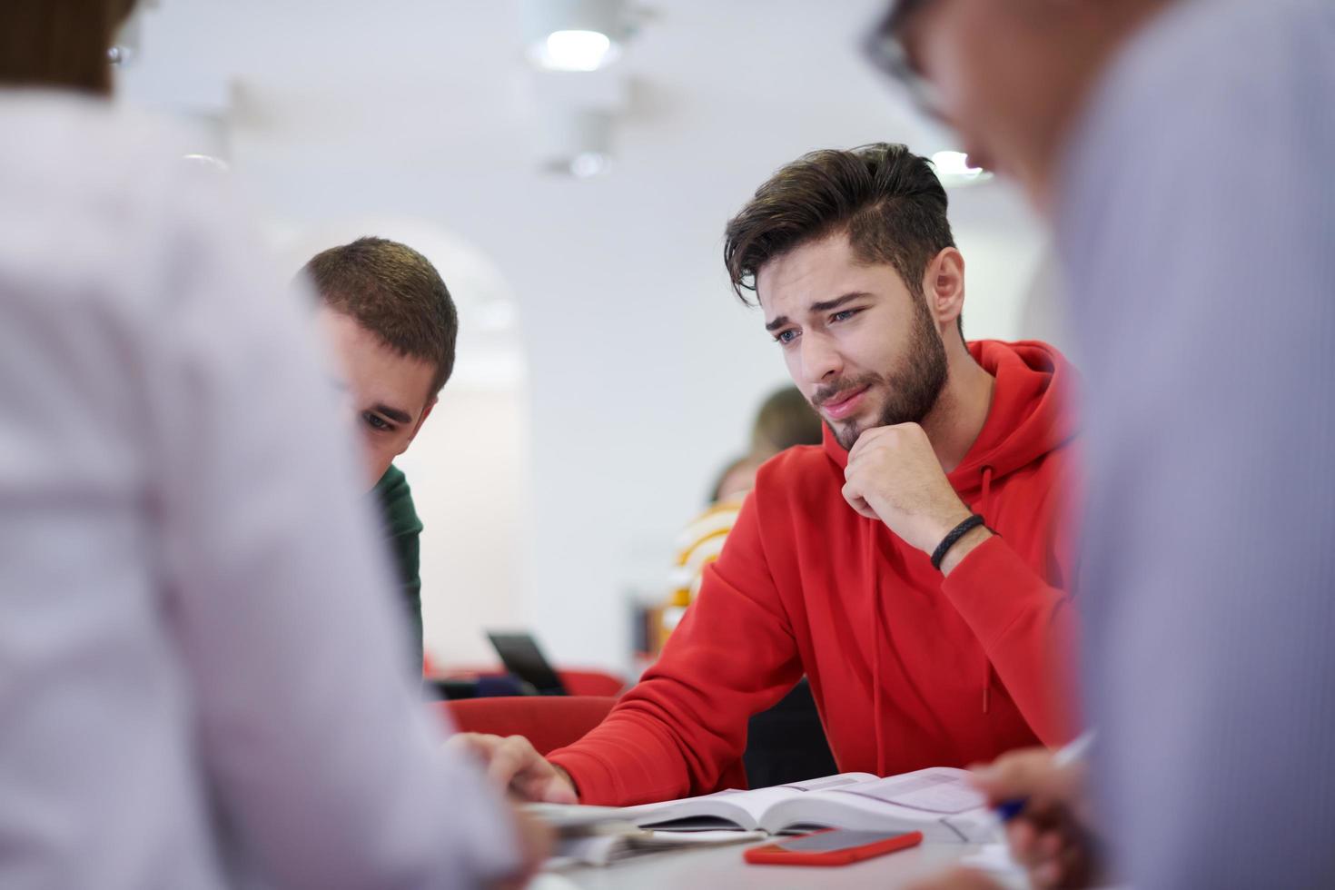 students group working on school project together on tablet computer at modern university photo