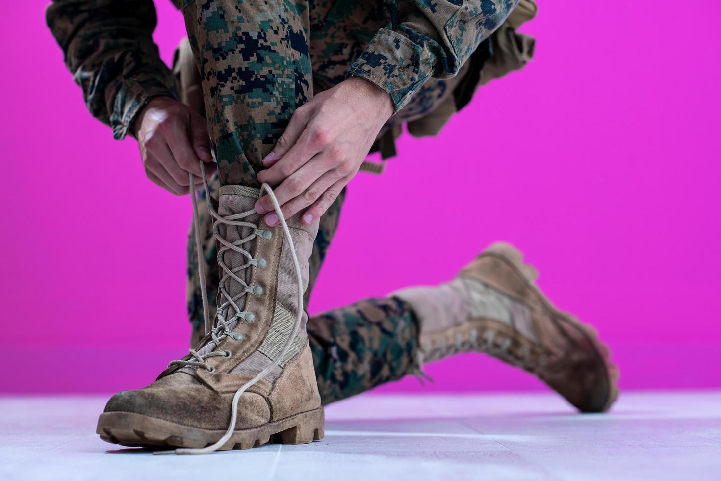 soldier tying the laces on his boots photo