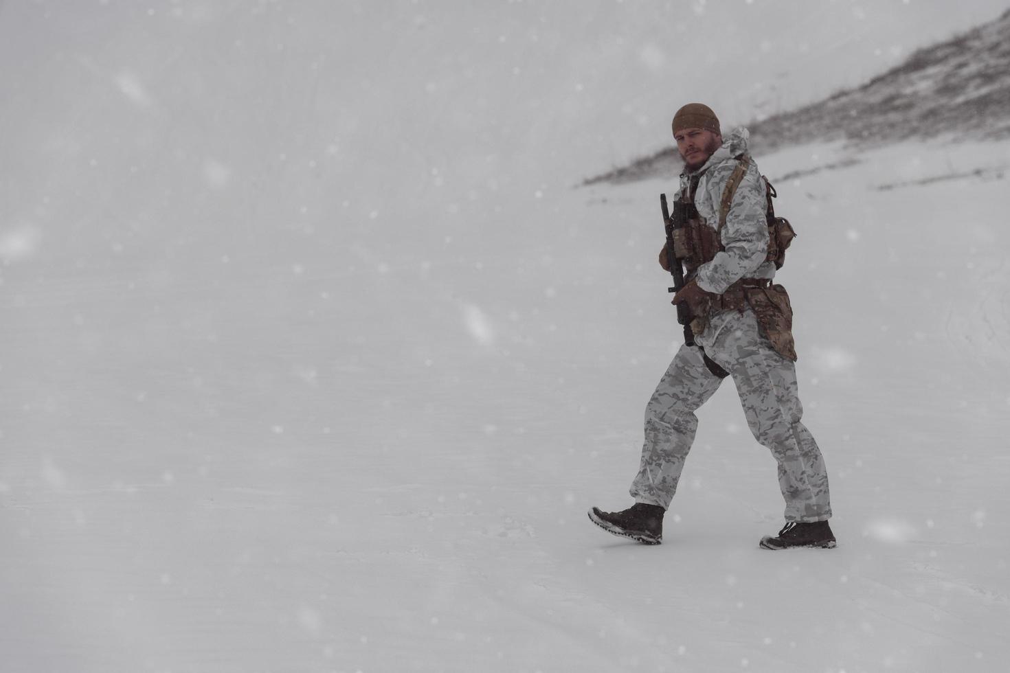 guerra de invierno en las montañas árticas. operación en condiciones frías. soldado en uniforme camuflado de invierno en el ejército de guerra moderno en un día de nieve en el campo de batalla del bosque con un rifle. enfoque selectivo foto