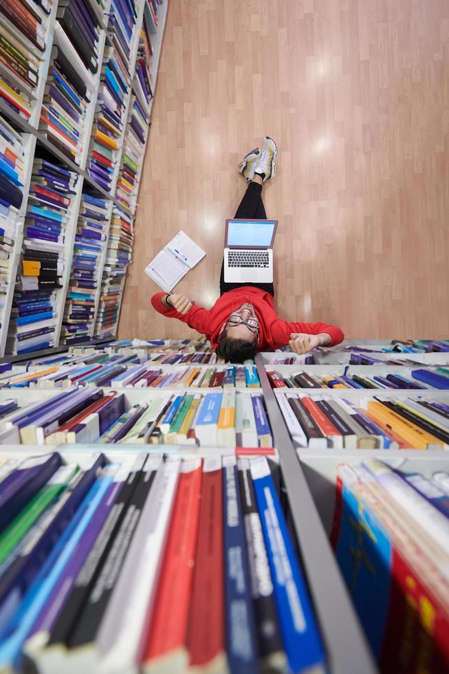 the students uses a notebook, laptop and a school library photo