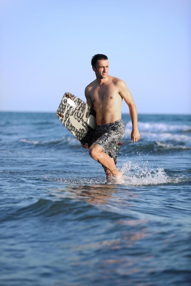 Portrait of a young  kitsurf  man at beach on sunset photo