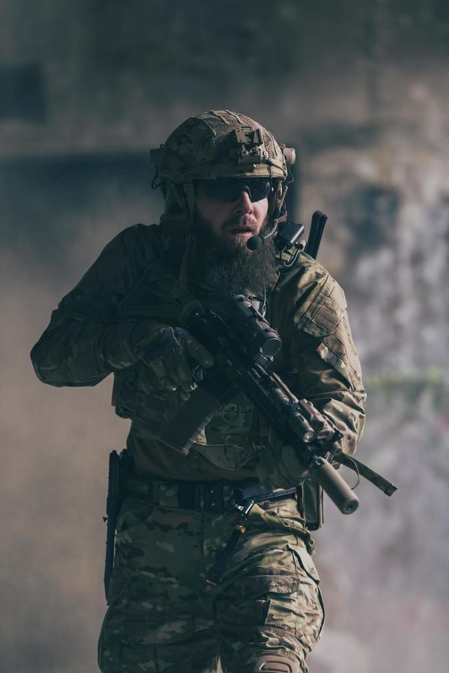 un soldado barbudo con uniforme de fuerzas especiales en una peligrosa acción militar en una peligrosa zona enemiga. enfoque selectivo foto