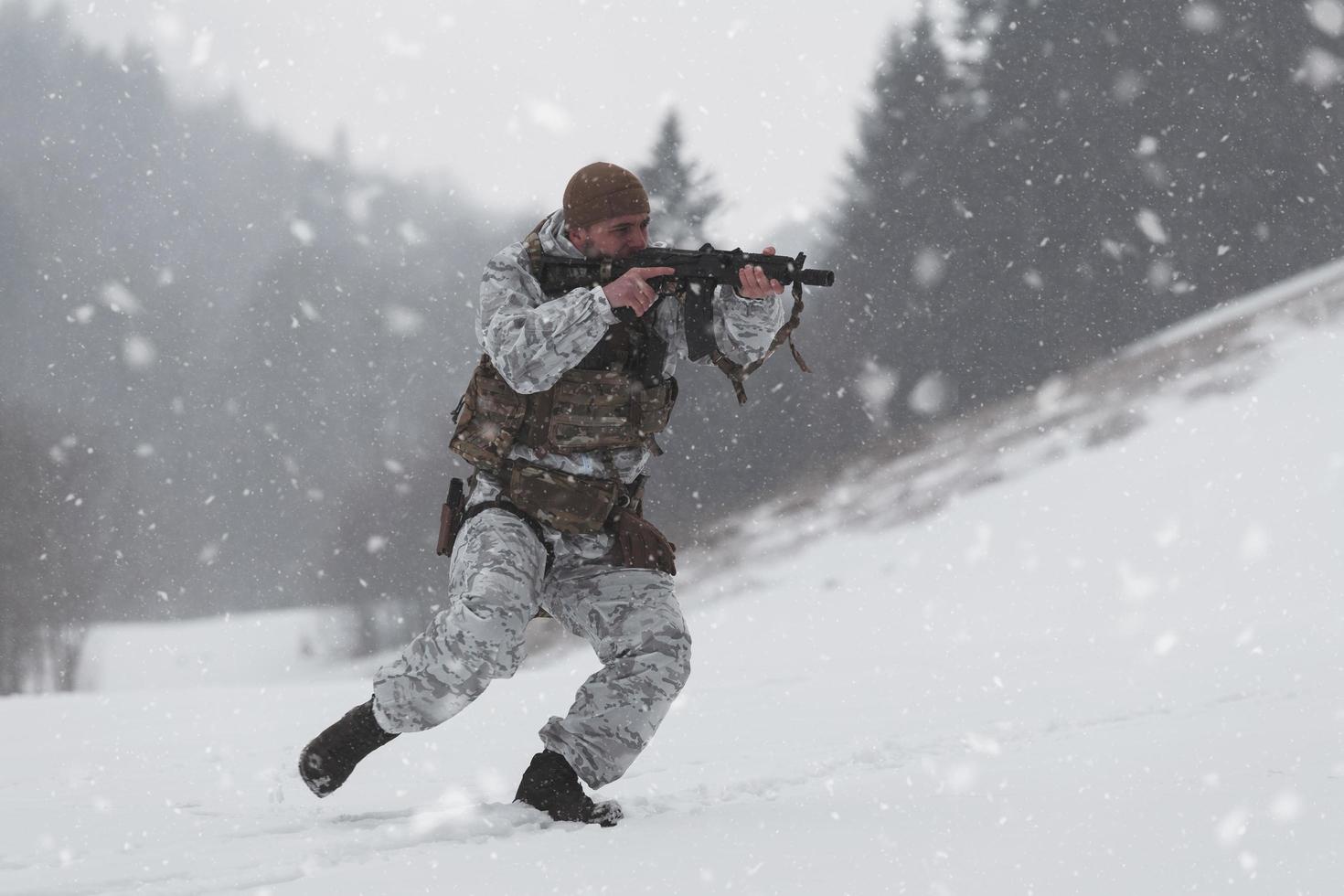 Winter war in the Arctic mountains. Operation in cold conditions.Soldier in winter camouflaged uniform in Modern warfare army on a snow day on forest battlefield with a rifle. Selective focus photo