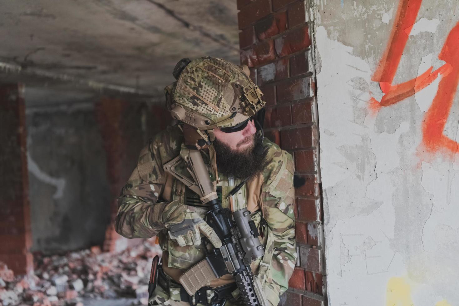 A bearded soldier in uniform of special forces in a dangerous military action in a dangerous enemy area. Selective focus photo