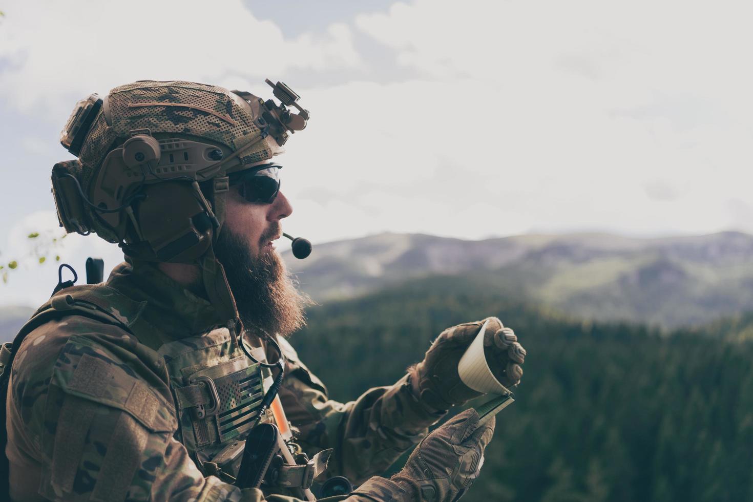 War concept. Bearded soldier in uniform of special forces in dangerous military action in dangerous enemy area studies attack tactics. Selective focus photo