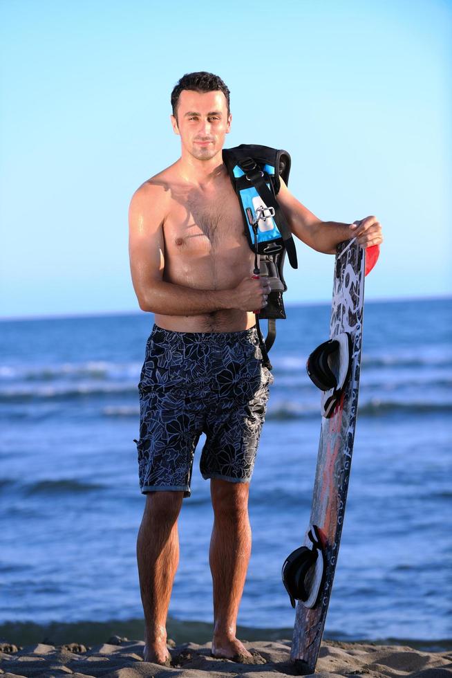 Portrait of a young  kitsurf  man at beach on sunset photo