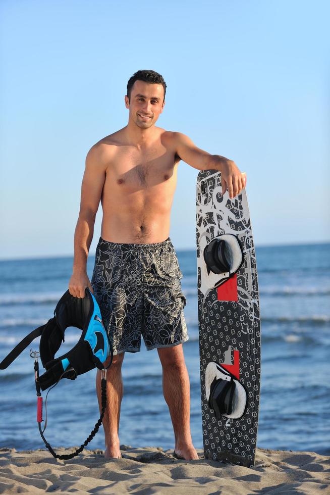 Portrait of a young  kitsurf  man at beach on sunset photo