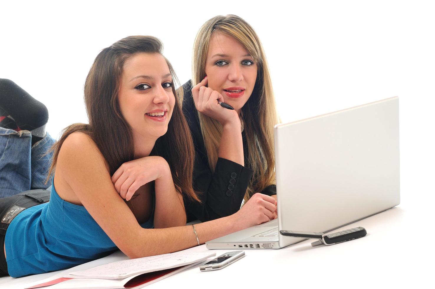 dos chicas jóvenes trabajan en una laptop aislada foto