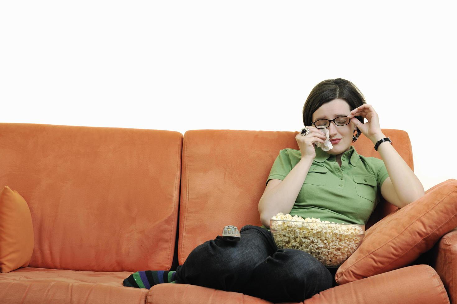 young woman eat popcorn on orange sofa photo