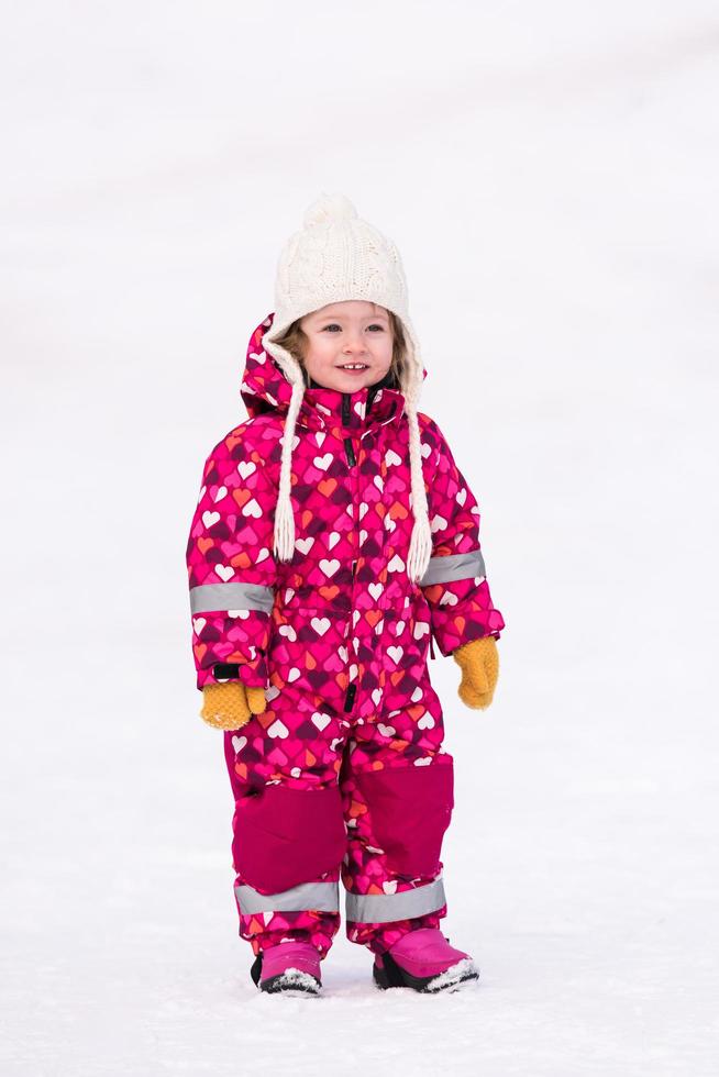 little girl having fun at snowy winter day photo