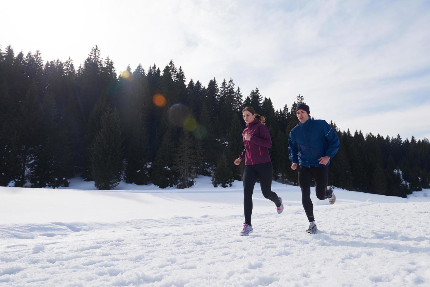 pareja trotando afuera en la nieve foto