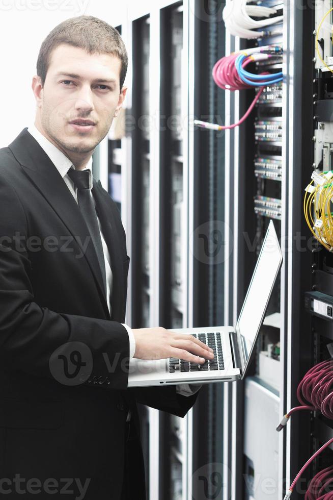 businessman with laptop in network server room photo