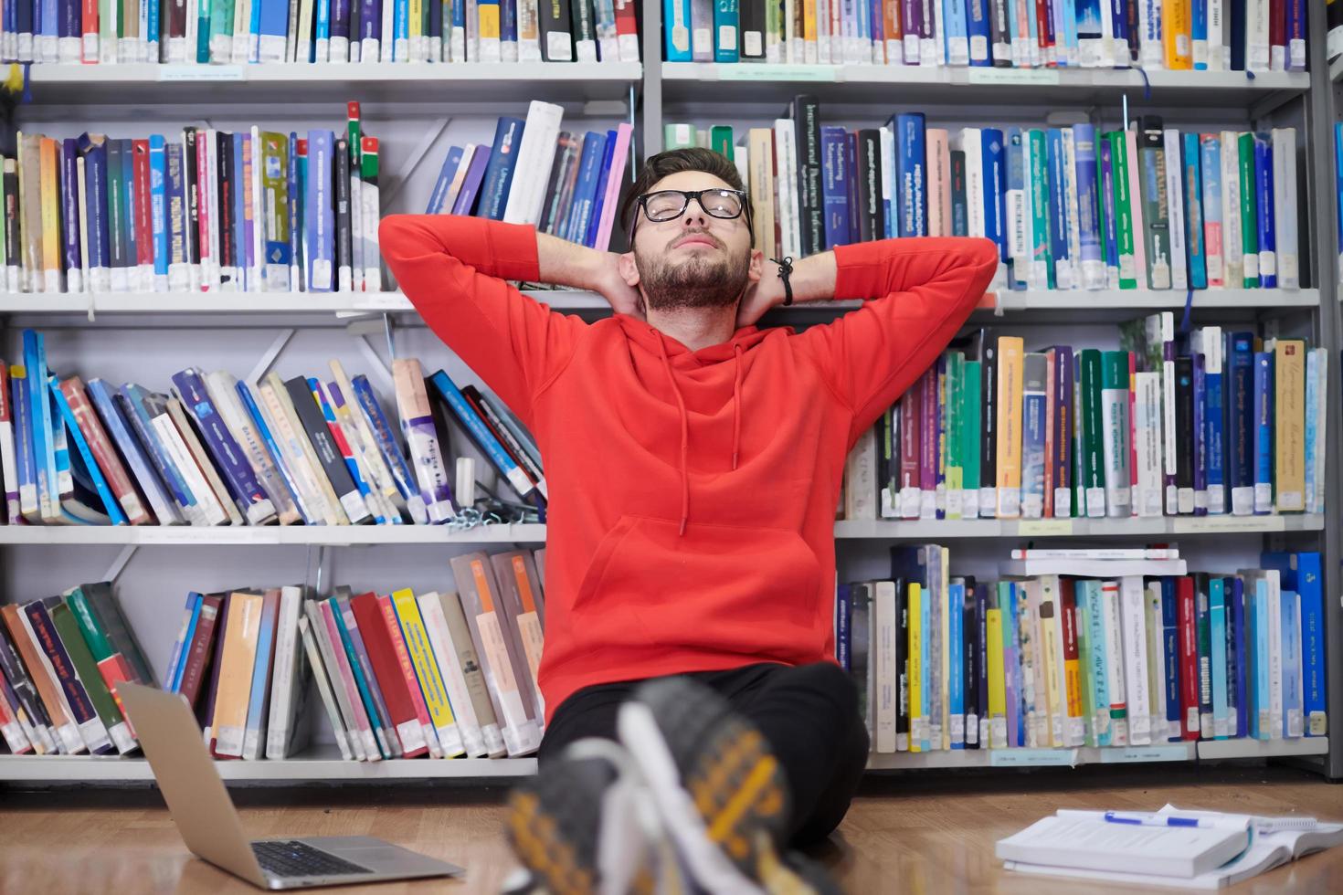 los estudiantes usan un cuaderno, una computadora portátil y una biblioteca escolar foto