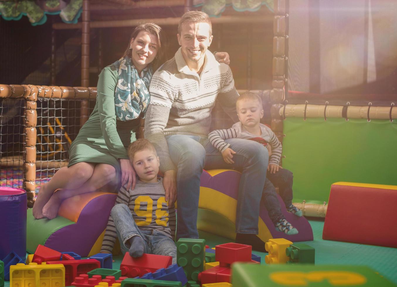 young parents and kids having fun at childrens playroom photo