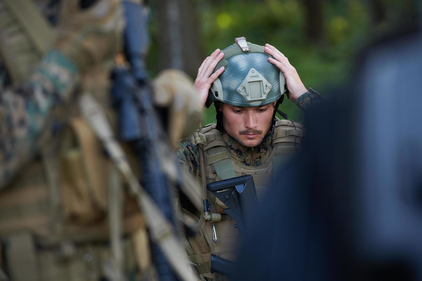 soldado preparando equipo táctico y de comunicación para la batalla de acción foto