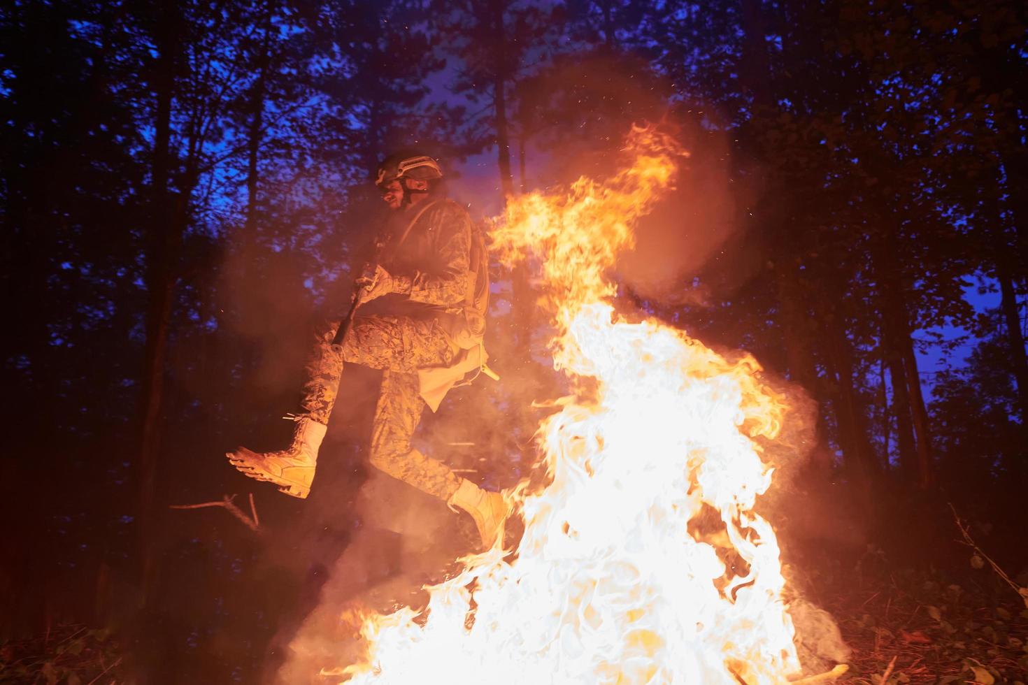 soldado en acción por la noche saltando sobre el fuego foto