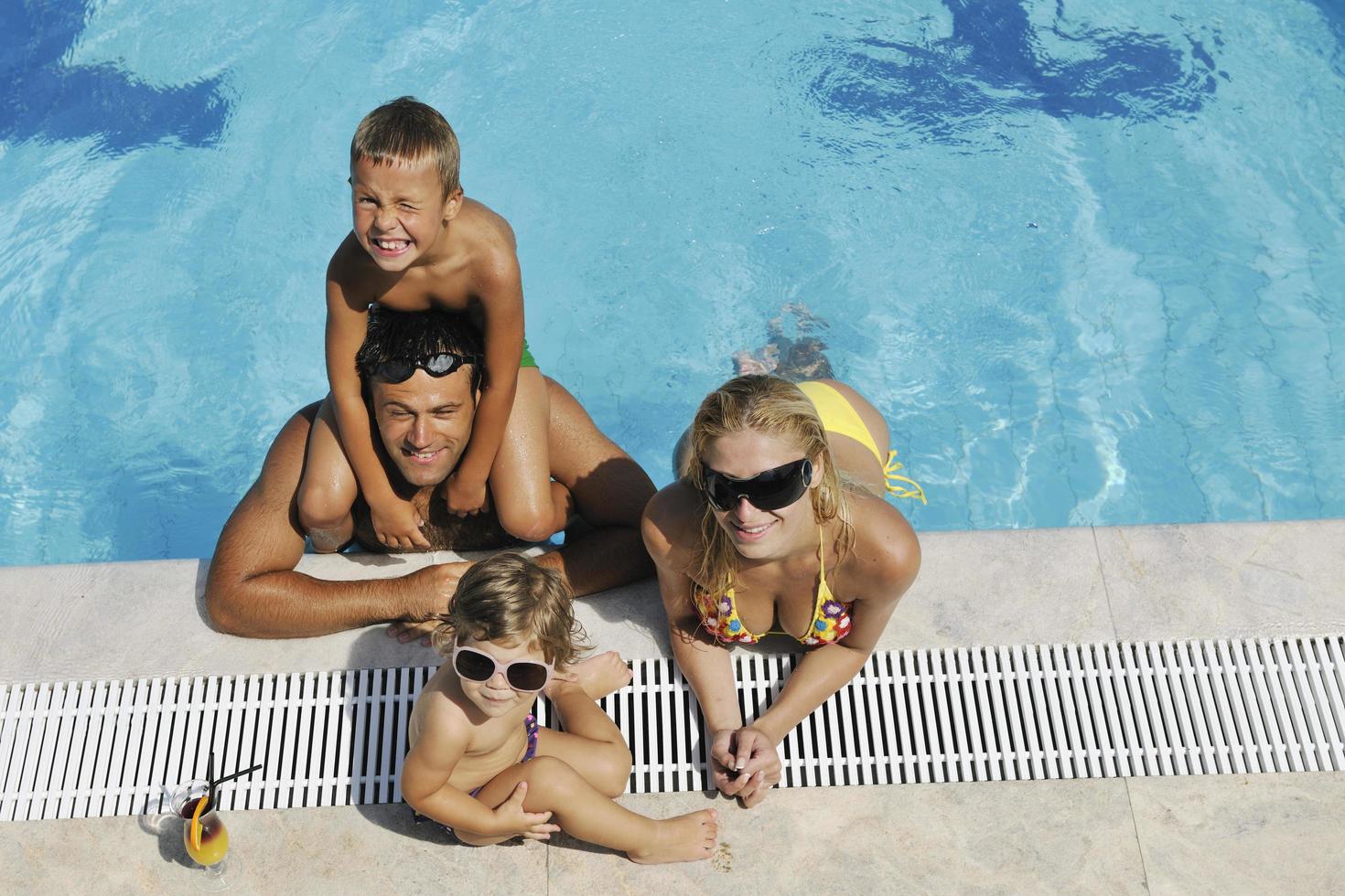 happy young family have fun on swimming pool photo