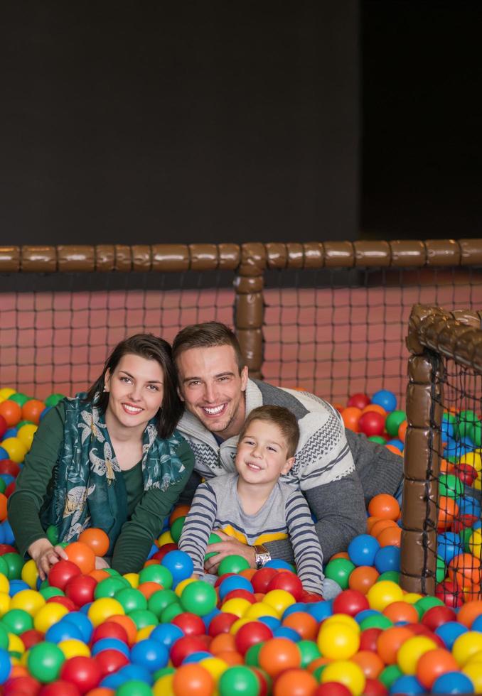 padres e hijos jugando en la piscina con bolas de colores foto