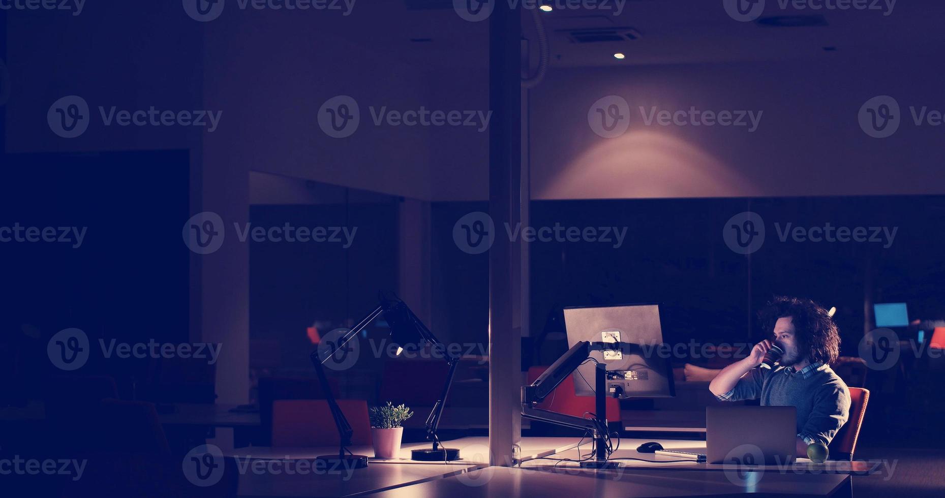 man working on computer in dark office photo