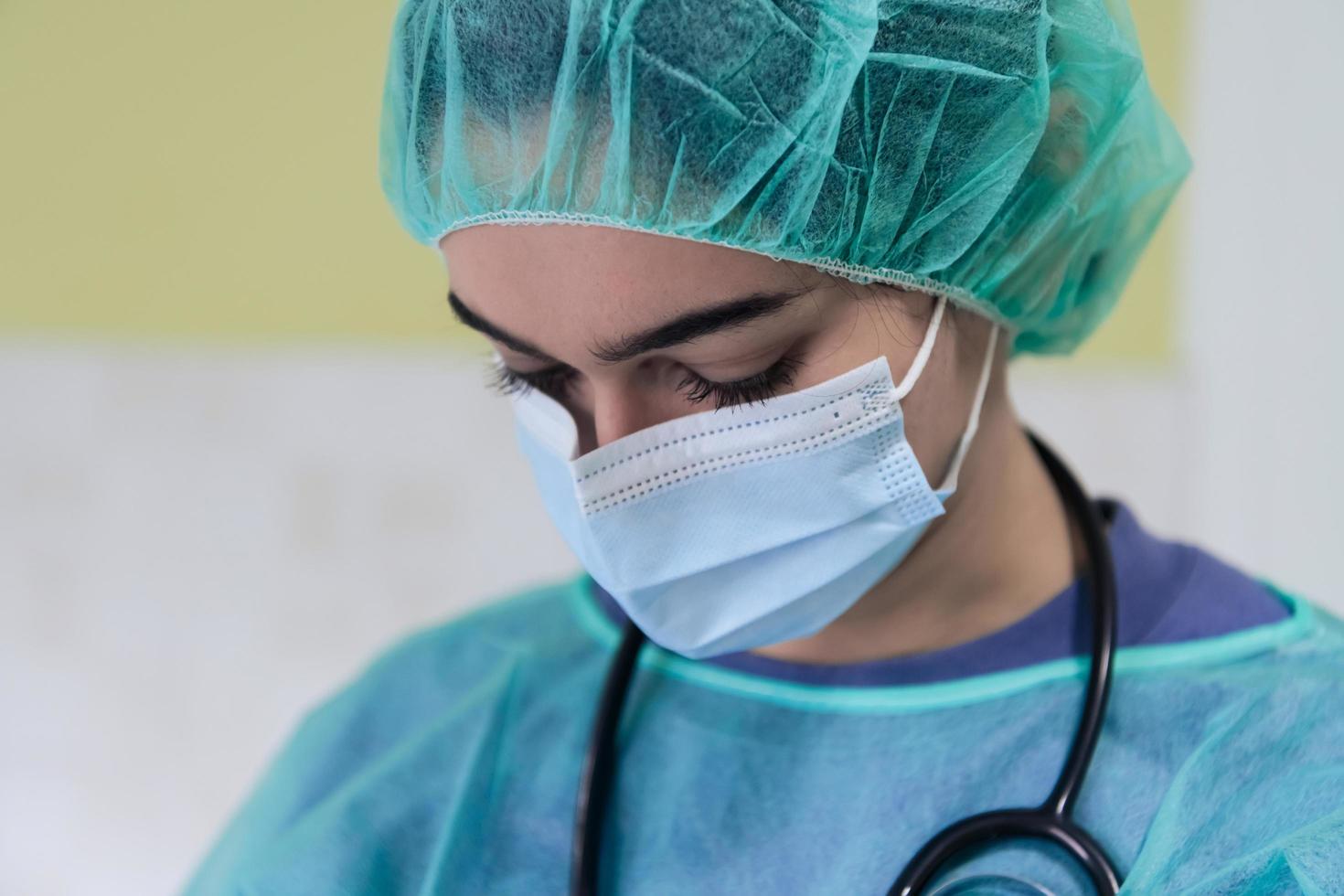 Portrait of sad and overwhelmed doctor wearing protective face mask, looking exhausted depressed and worried due to coronavirus outbreak. Emotional stressed, health care workers and COVID-19. photo