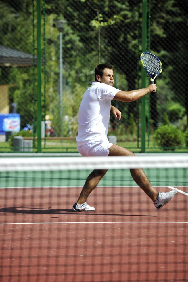 joven jugar al tenis al aire libre foto