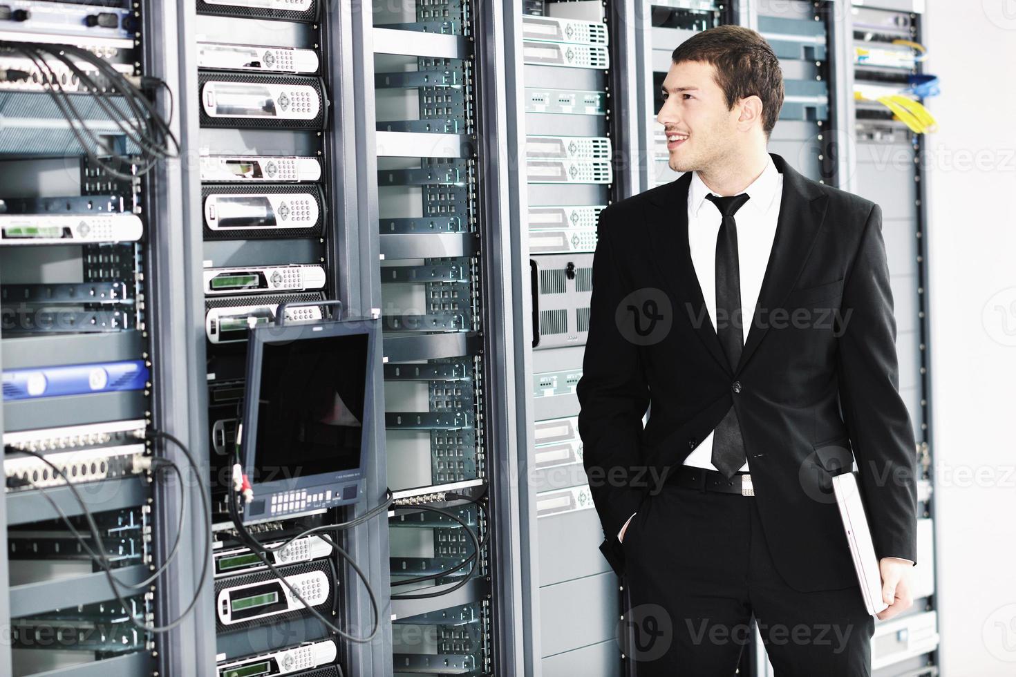 businessman with laptop in network server room photo