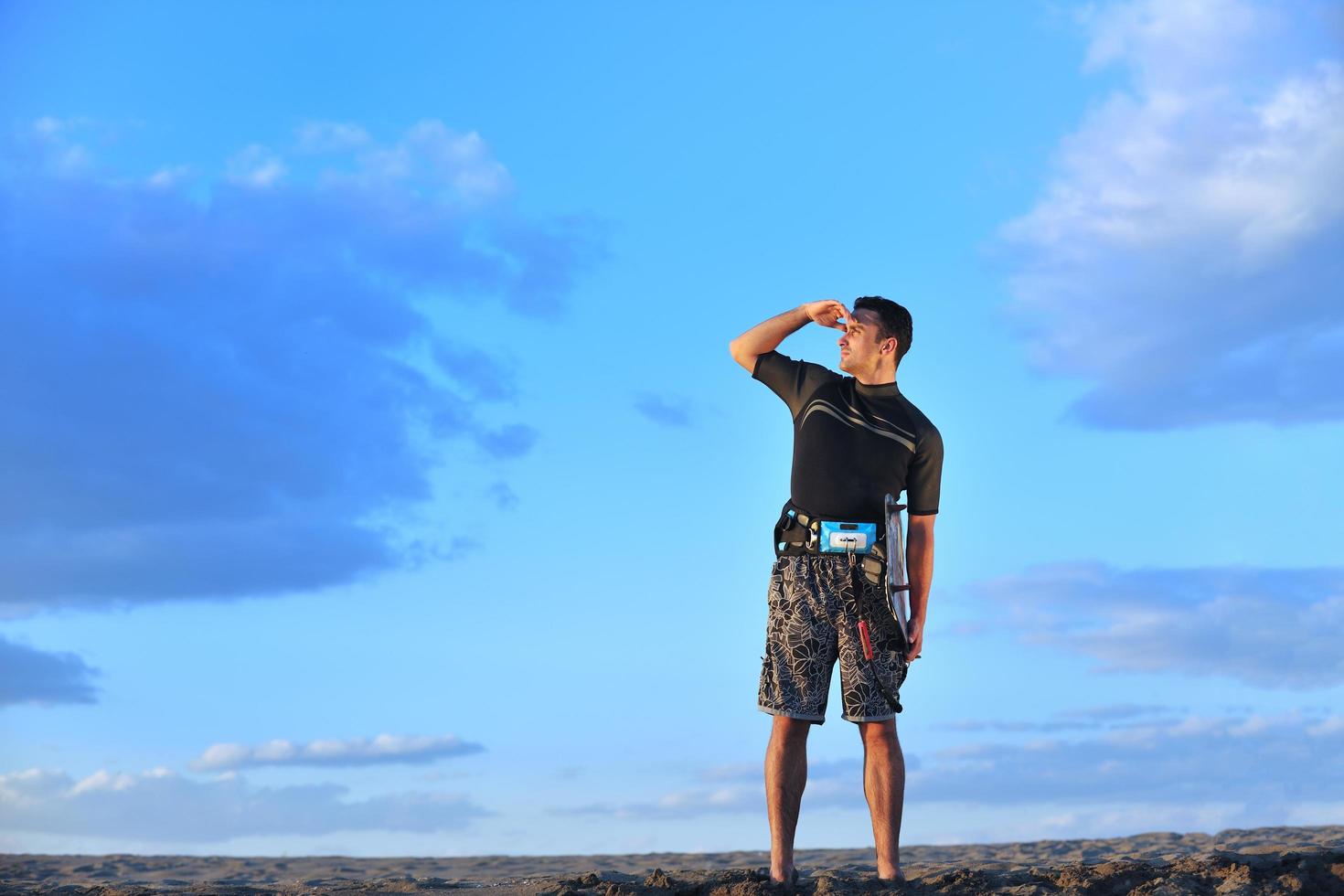 Portrait of a young  kitsurf  man at beach on sunset photo