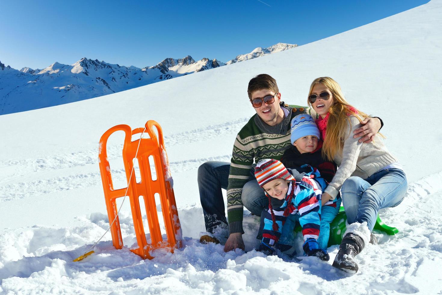 family having fun on fresh snow at winter vacation photo