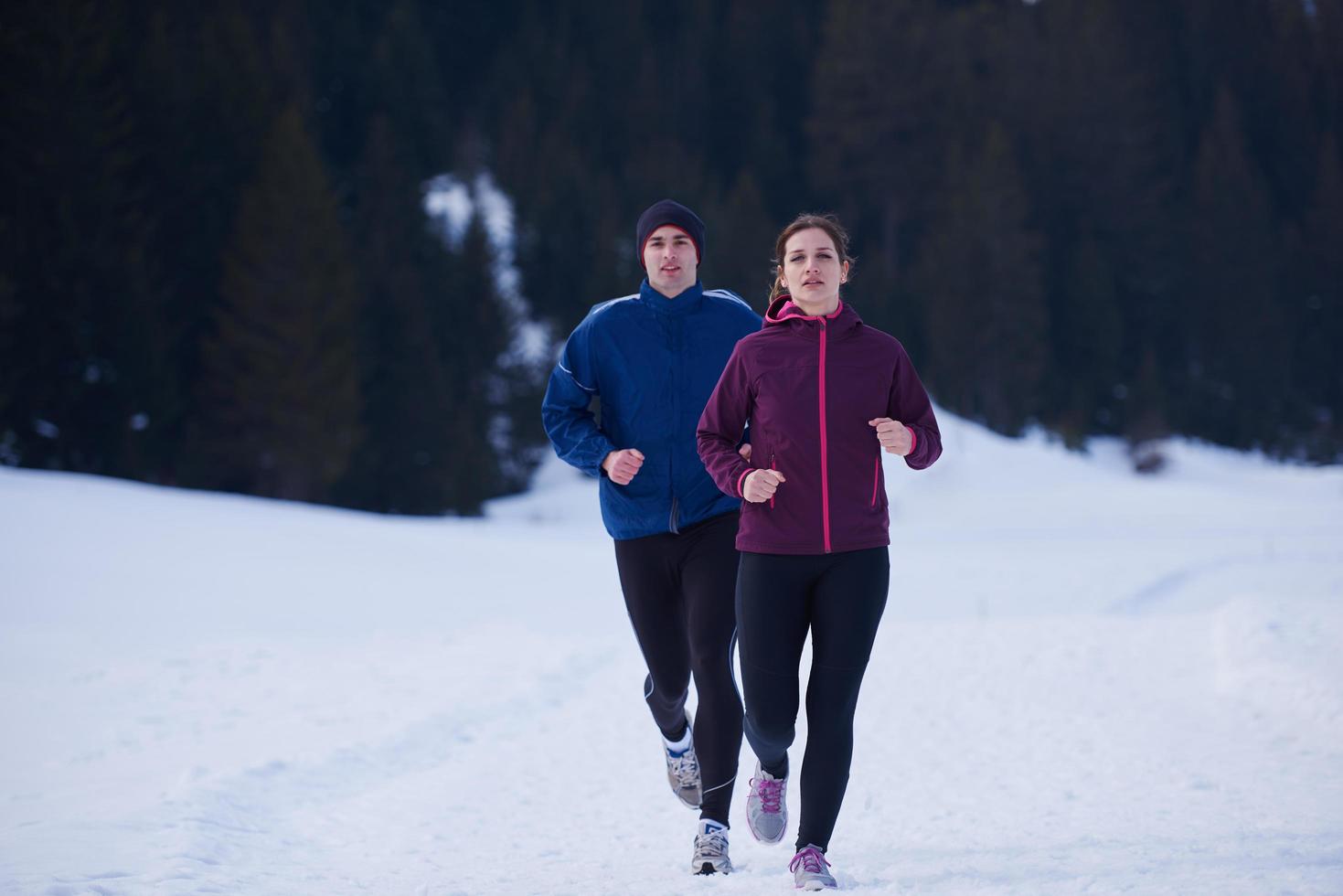 pareja trotando afuera en la nieve foto