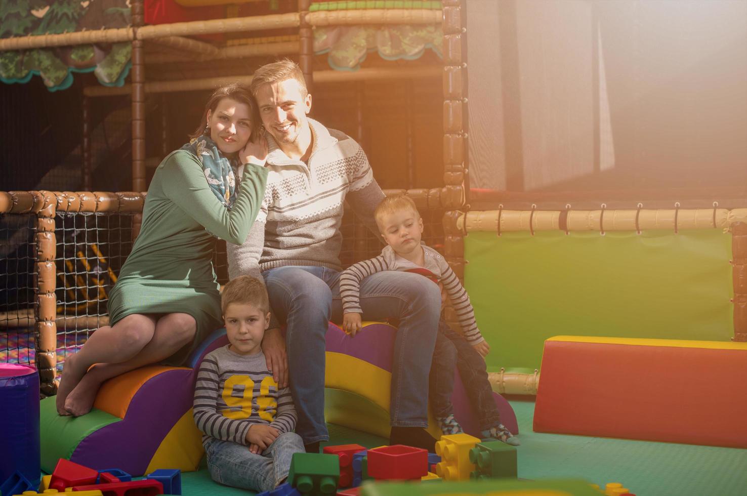 young parents and kids having fun at childrens playroom photo