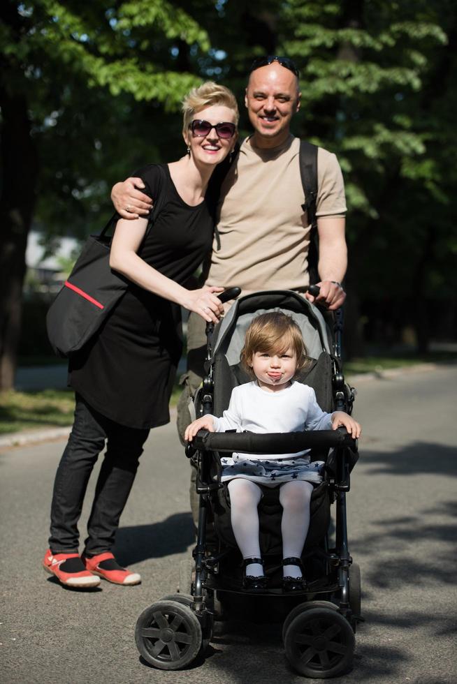 couple with baby pram in summer park photo