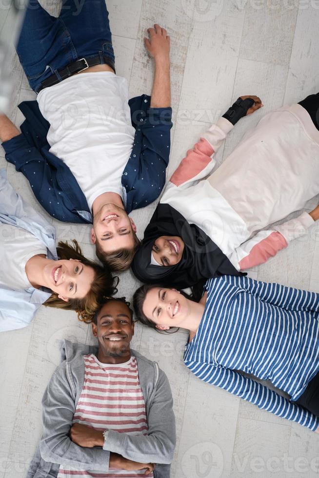 top view of a diverse group of people lying on the floor and symbolizing togetherness photo