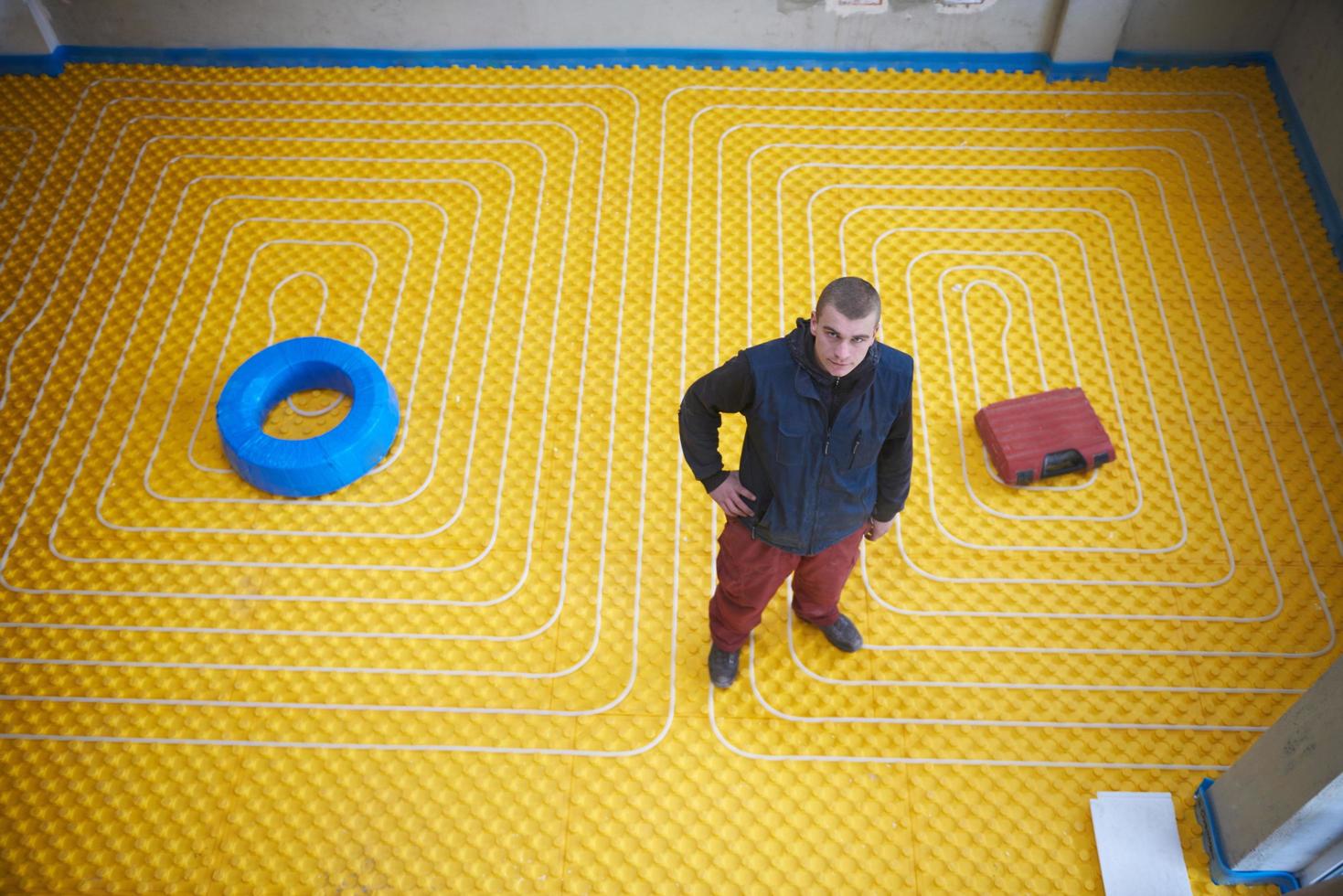 workers installing underfloor heating system photo