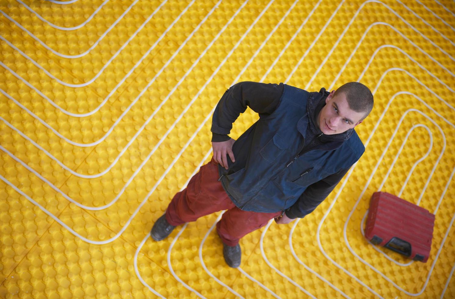 workers installing underfloor heating system photo