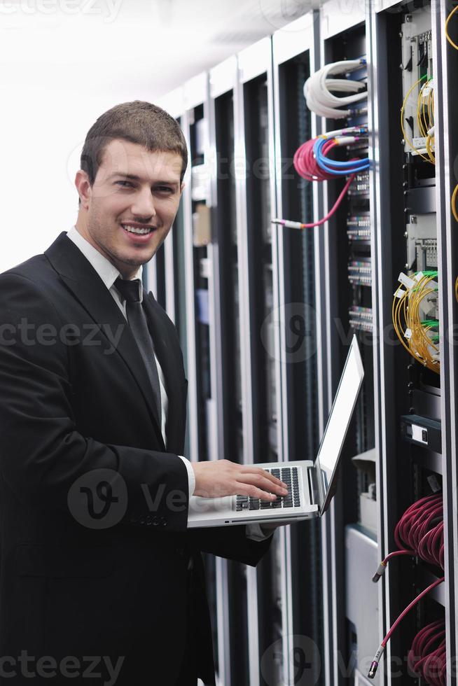 businessman with laptop in network server room photo