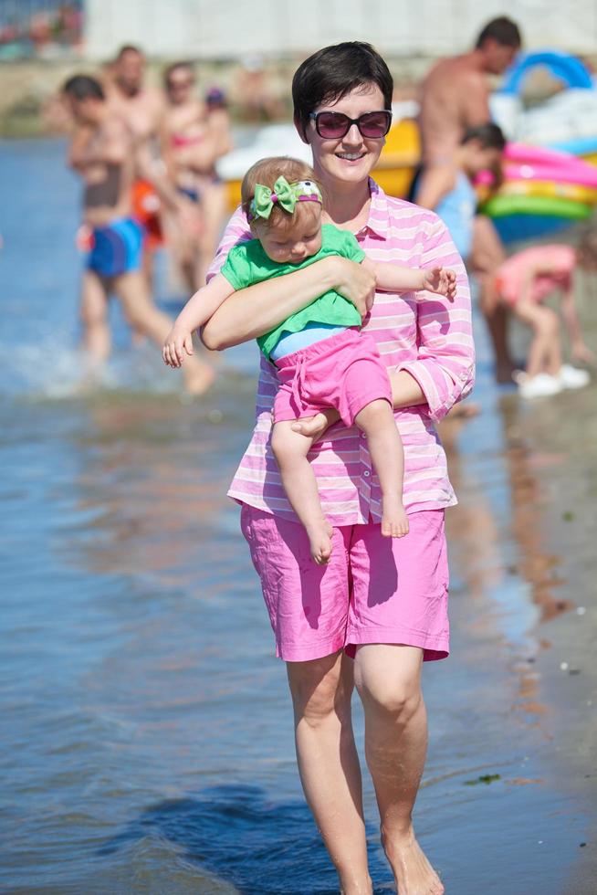 mamá y bebé en la playa se divierten foto