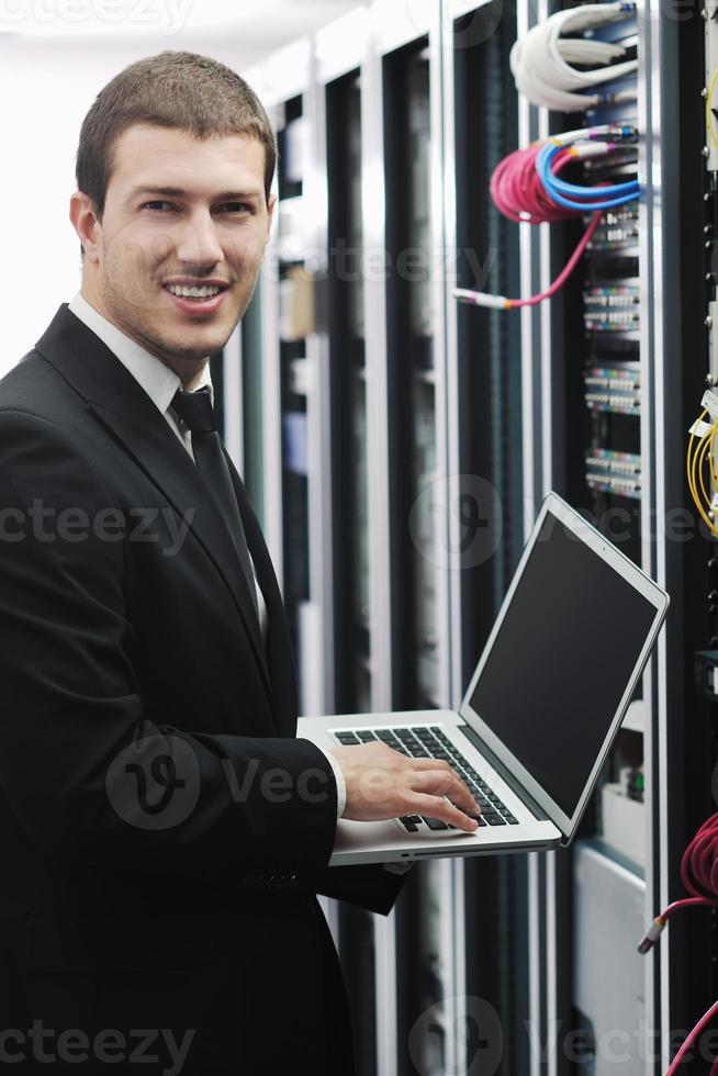 businessman with laptop in network server room photo