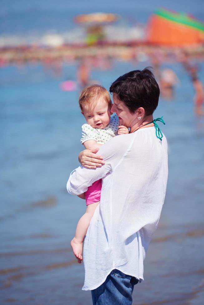 mother walking on beach and push baby carriage photo