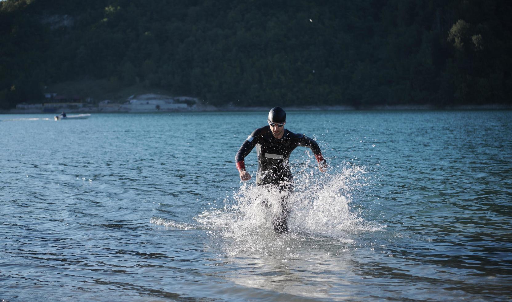 atleta de triatlón comenzando a nadar en el lago foto