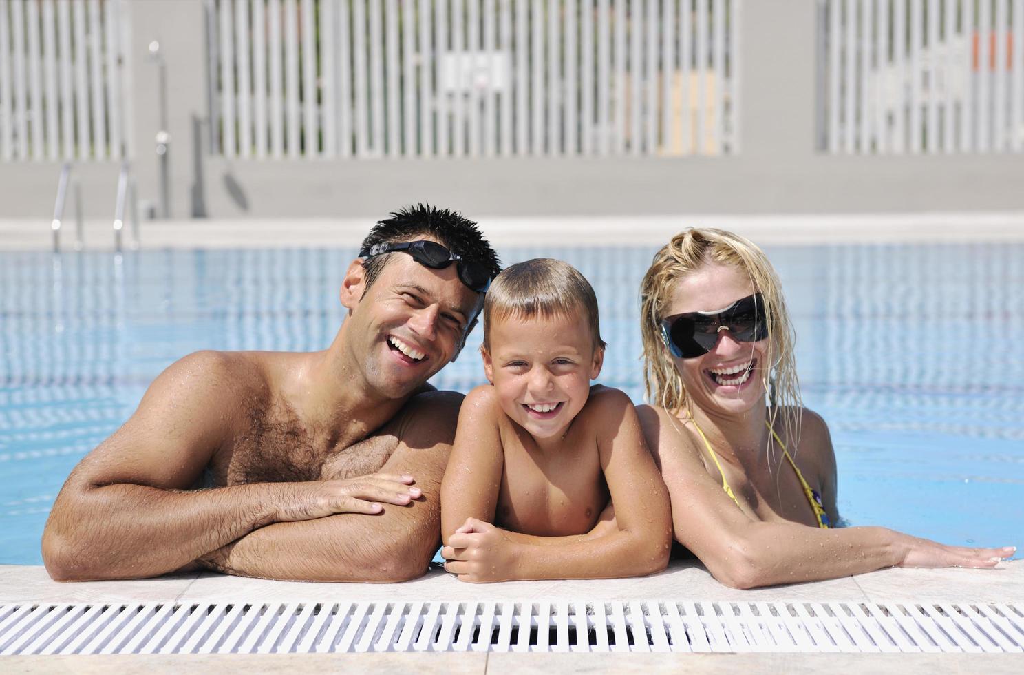 happy young family have fun on swimming pool photo