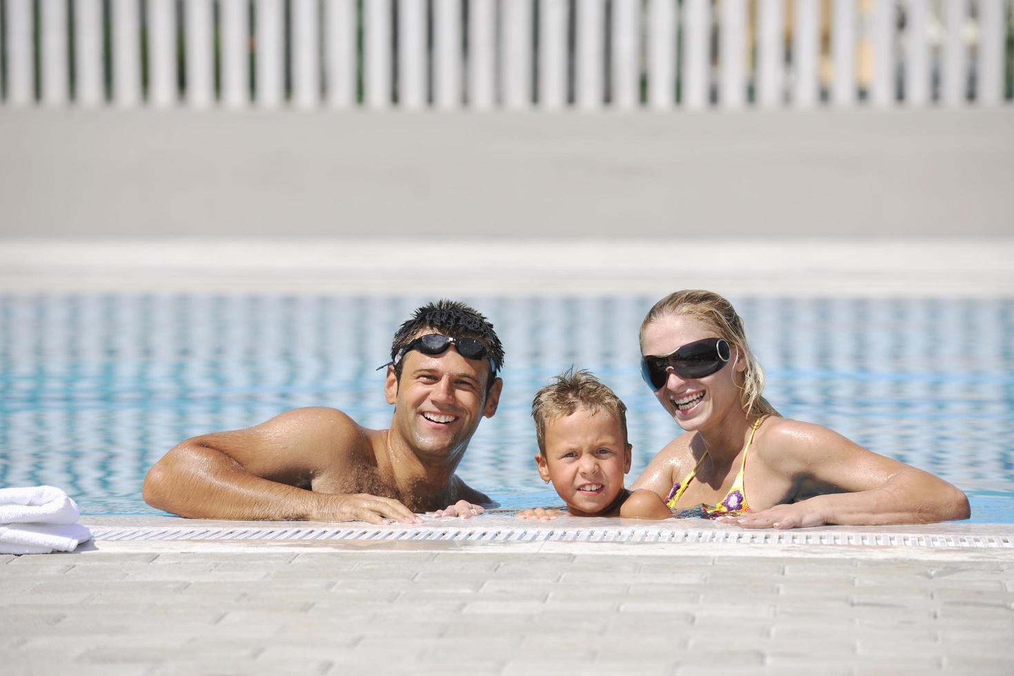 happy young family have fun on swimming pool photo