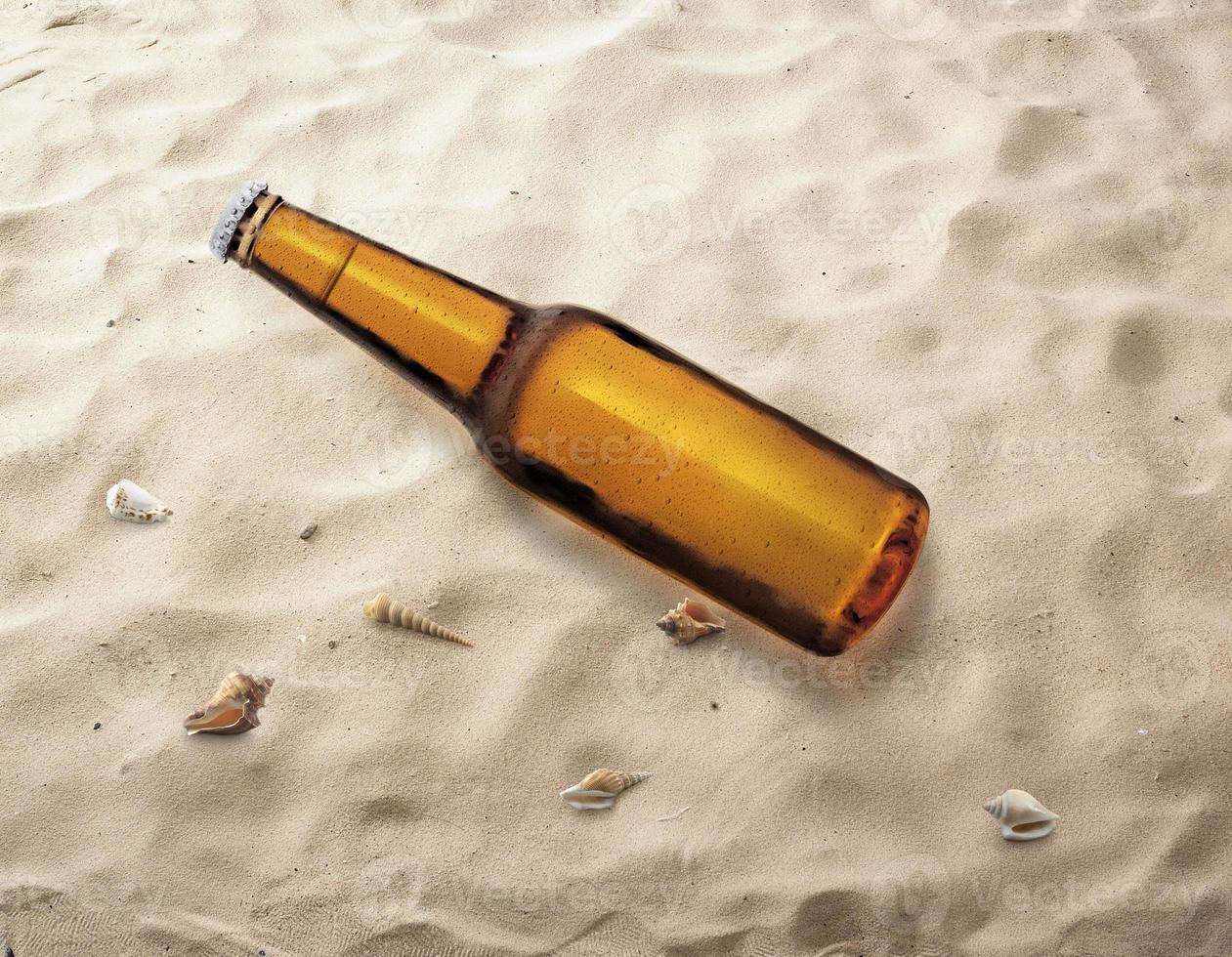 Bottle of beer on the beach being carried by sea waves to the shore photo