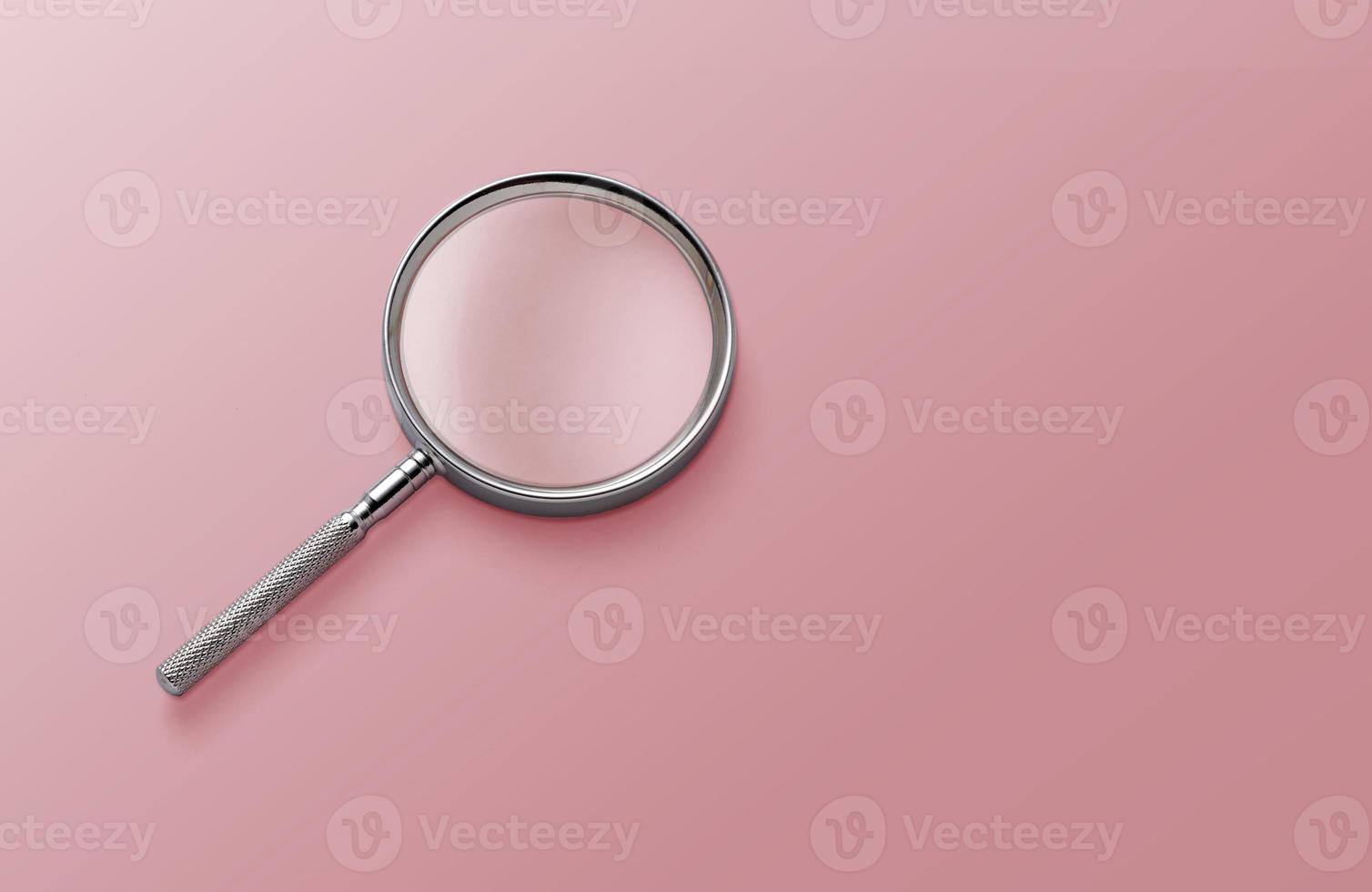 magnifying glass on pink background top view lying flat copy space concept photo