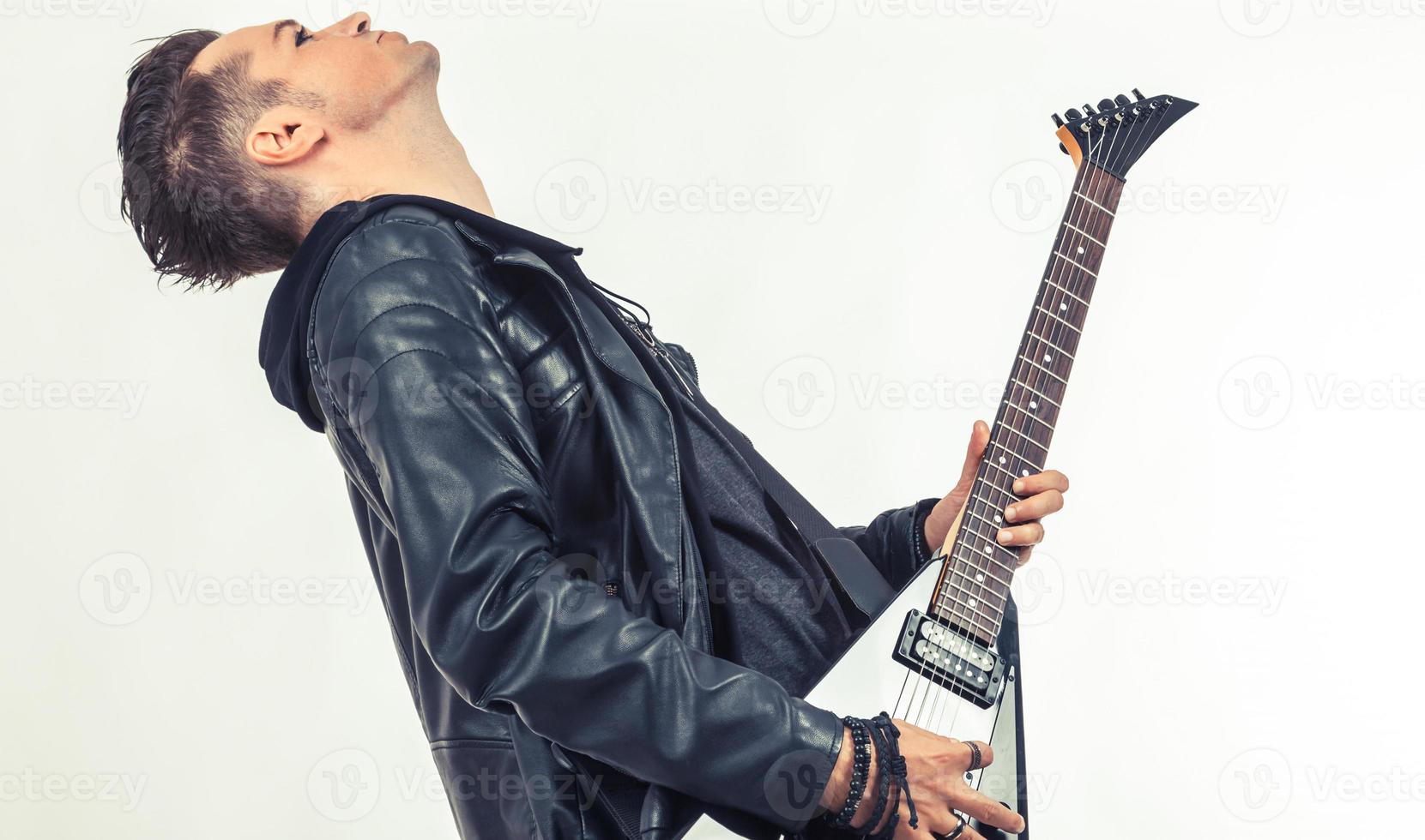 Side view of heavy metal musician playing electric guitar. photo