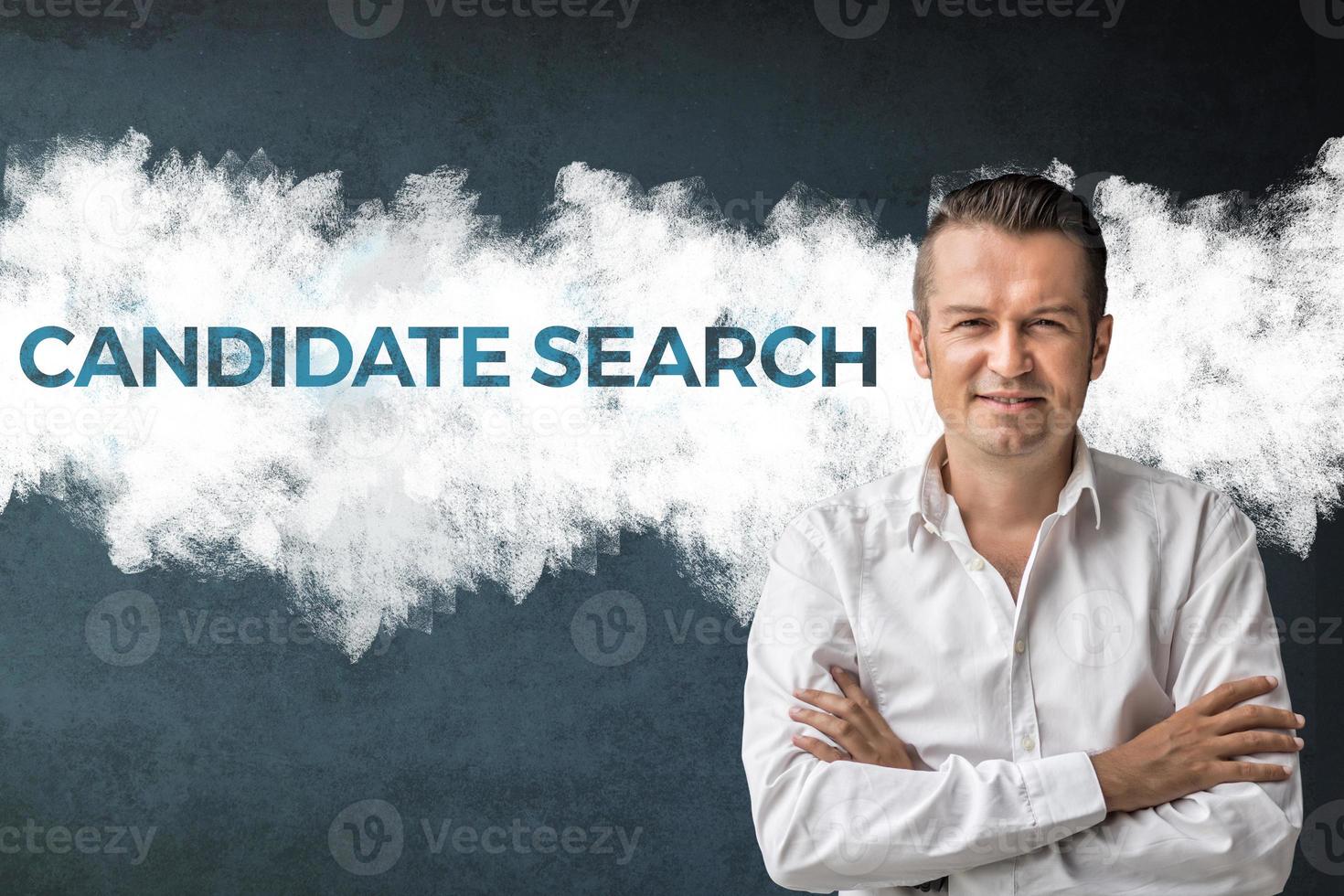 Candidate search. Confident businessman with arms crossed standing next to sign on the wall. Job search concept. photo