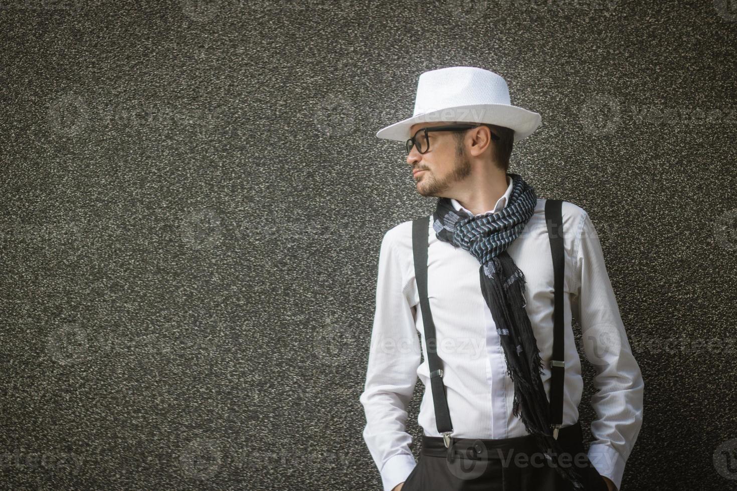 Fashionable man with hat against grey wall. photo