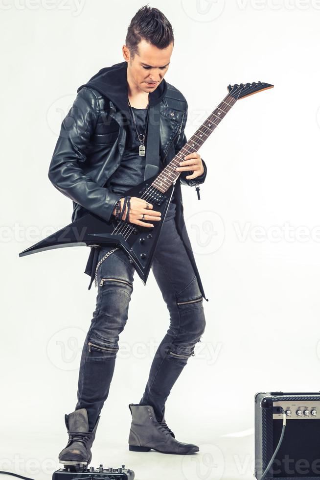 Full length of hard rock musician playing electric guitar. photo